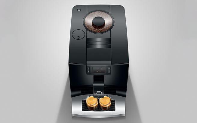 bovenaanzicht van het koffietoestel met zicht op de koffiebonen, terwijl twee koffies gezet worden